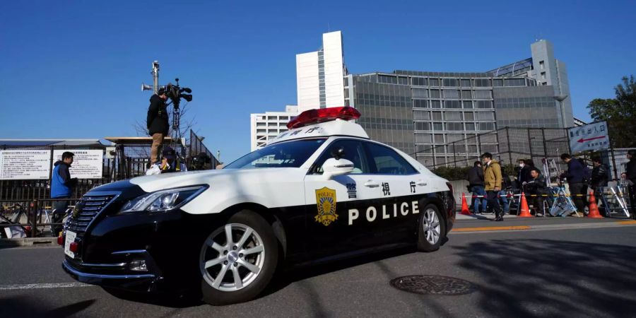 Ein Polizeifahrzeug fährt vor dem Tokyo Detention Center.