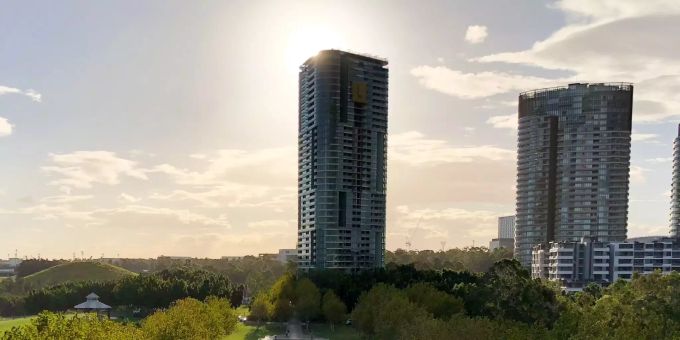 Die Sonne strahlt hinter dem Opal-Tower in Sydney hervor.