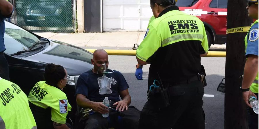 Einer der Feuerwehrmänner wird nach dem Betreten des brennendes Hauses behandelt.