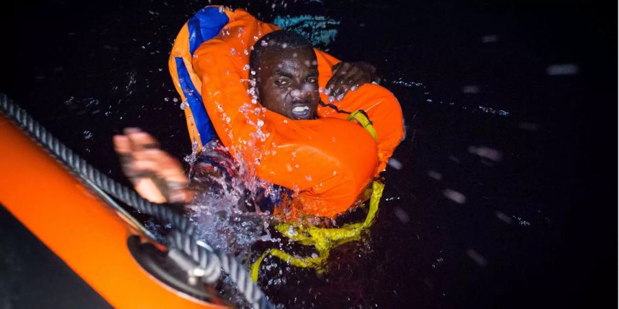 Ein Mensch schwimmt in den frühen Morgenstunden des 2. August 2018 verzweifelt auf ein Rettungsschiff vor der Küste Libyens zu. Retter der spanischen gemeinnützigen Organisation Open Arms retteten 87 Migranten vor der Küste Libyens in einer dramatischen Nachtoperation. Die Gruppe bestand aus acht Minderjährigen.