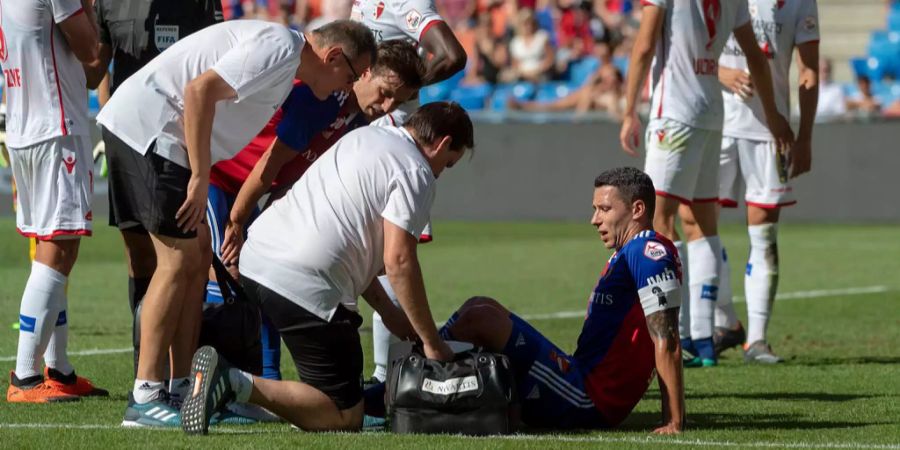 Basels Marek Suchy, Mitte, sitzt verletzt am Boden im Fussball Meisterschaftsspiel der Super League zwischen dem FC Basel 1893 und dem FC Sion im Stadion St. Jakob-Park in Basel, am Sonntag, 12. August 2018.