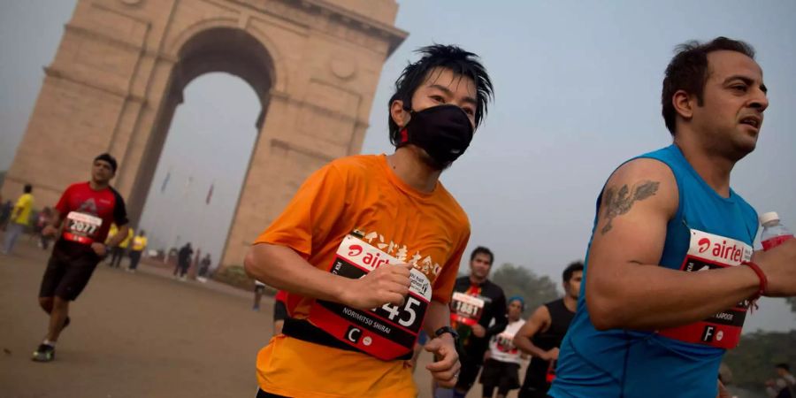 Einige Läufer trugen eine Schutzmaske, um die Gesundheitsrisiken beim Halbmarathon in Neu Delhi zu reduzieren.