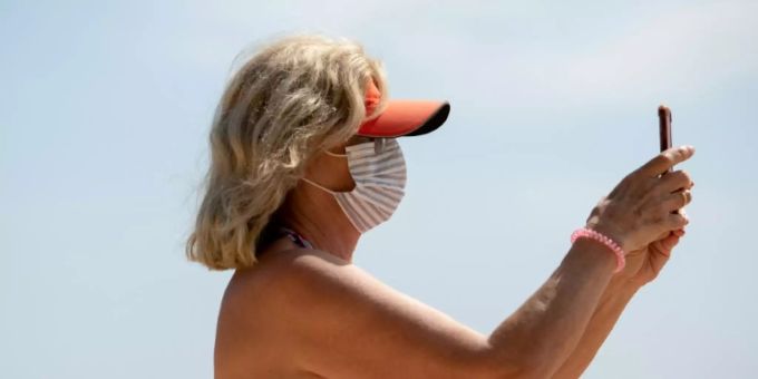 Maskenträgerin an spanischem Strand Maskenträgerin an spanischem Strand