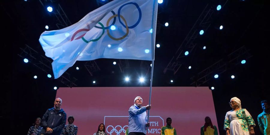 Thomas Bach, Präsident des Internationalen Olympischen Komitees, schwenkt bei der Abschlusszeremonie der Olympische Jugendspiele 2018 in Buenos Aires (ARG) die Olympische Flagge.