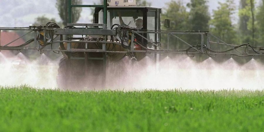 Ein Landwirt versprüht mithilfe seines Traktors Pflanzenschutzmittel in Sargans.