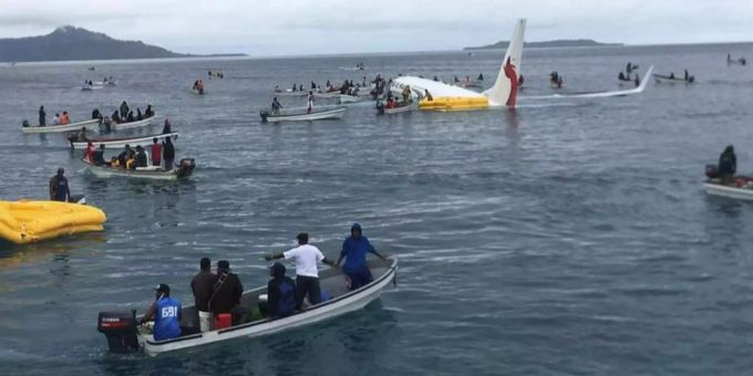 Die Maschine der Air Niugini schwimmt in der Lagune, Einheimische kommen den Passagieren zu Hilfe. Die Maschine der Air Niugini schwimmt in der Lagune, Einheimische kommen den Passagieren zu Hilfe.