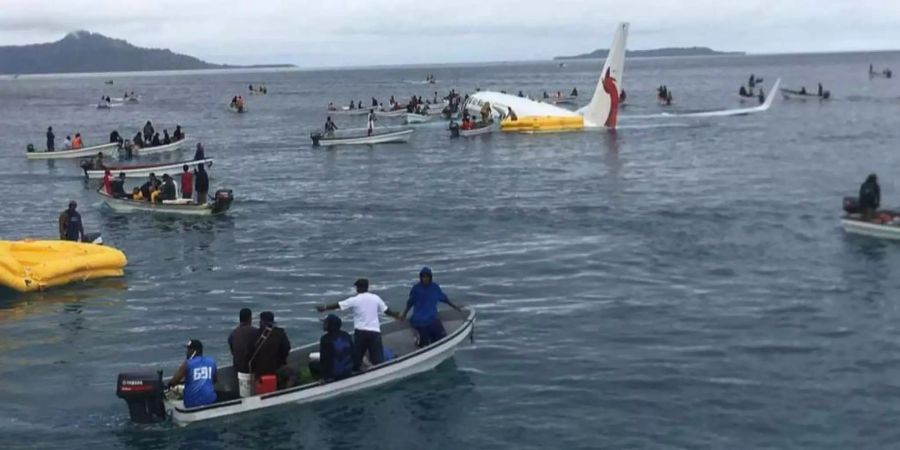 Die Maschine der Air Niugini schwimmt in der Lagune, Einheimische kommen den Passagieren zu Hilfe.