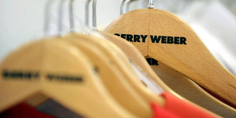 Kleiderbügel mit der Aufschrift Gerry Weber hängen an einer Garderobe.