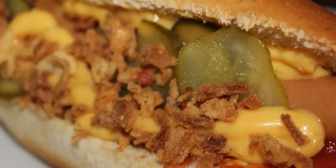 Ein Hotdog liegt auf einem Tisch. Ein Hotdog liegt auf einem Tisch.