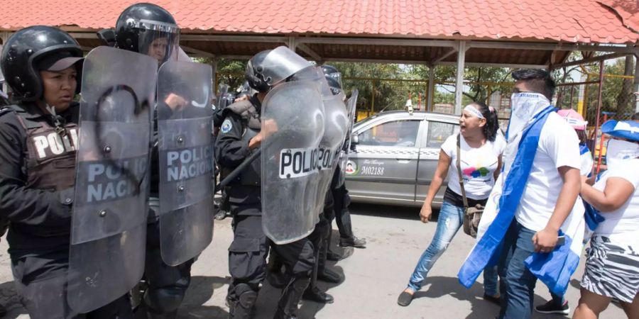 Die Polizei hält die Demonstranten in Nicaragua mit Schildern zurück.