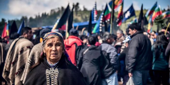 Menschen vom indigenen Volk der Mapuche nehmen auf einem Friedhof an einer Beerdigung teil.