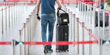 Mann mit Koffer an einem Flughafen