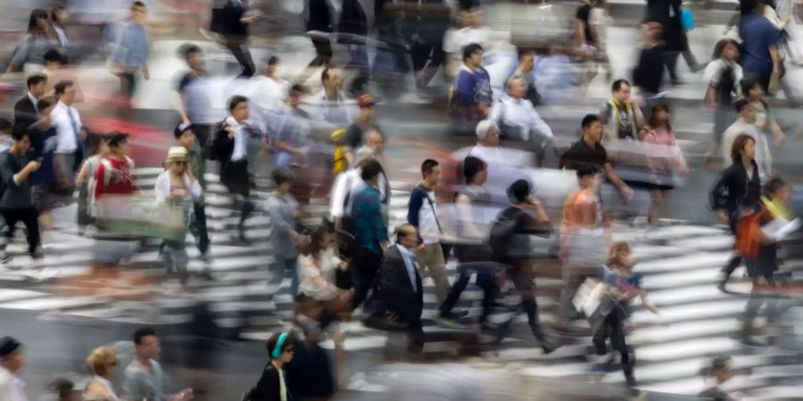 Zahlreiche Fussgänger überqueren eine Kreuzung in Japan.