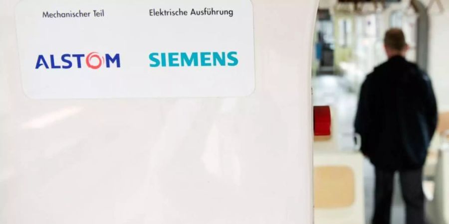 Die Logos der Industriekonzerne Alstom und Siemens kleben in einer Stadtbahn der hannoverschen Verkehrsbetriebe Üstra. Foto: Julian Stratenschulte