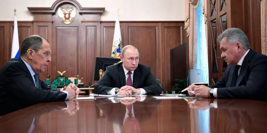 Wladimir Putin (M), Präsident von Russland, nimmt an einem Treffen mit Sergej Lawrow (l) und Sergei Shoigu, Verteidigungsminister von Russland, im Kreml teil.