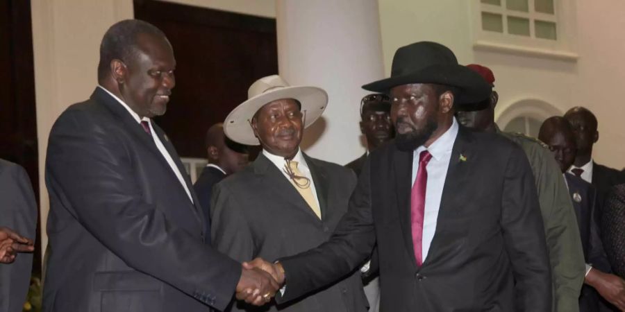 Der frühere Vize-Präsident Südsudans Riek Machar (l.)  begrüsst den südsudanesischen Präsidenten Salva Kiir (r.) zu den Friedensverhandlungen in Uganda.