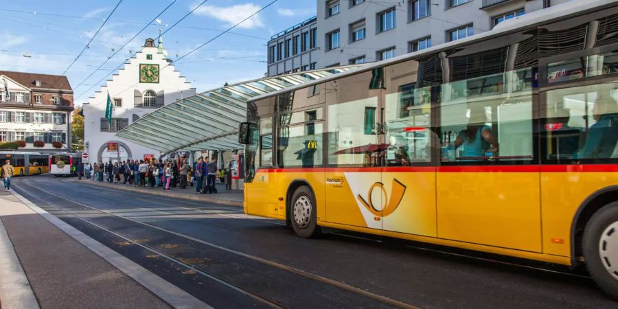 Ein Postauto fährt in einen Busbahnhof ein.