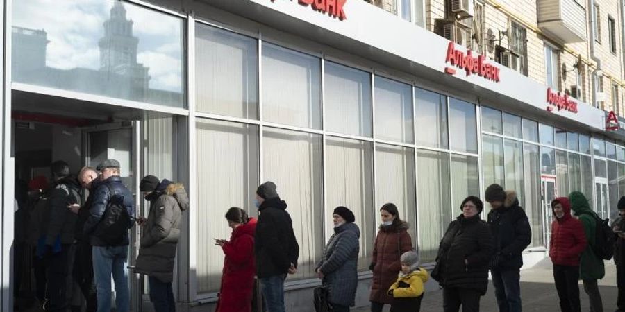 Menschen in Moskau stehen vor einem Geldautomaten der Alfa Bank Schlange. Foto: Victor Berzkin/AP/dpa