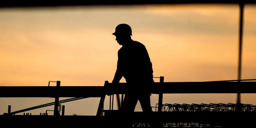 Die Silhouette eines Bauarbeiters am Morgen: Im Konflikt um den tariflichen Mindestlohn in der Bauwirtschaft haben die Arbeitgeber den Schlichterspruch abgelehnt.