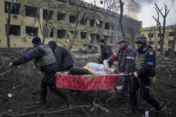 Ukrainian emergency employees and volunteers carry an injured pregnant woman from a maternity hospital damaged by shelling in Mariupol, Ukraine, Wednesday, March 9, 2022. The baby was born dead. Half an hour later, the mother died too. (AP Photo/Evgeniy Maloletka) mariupol