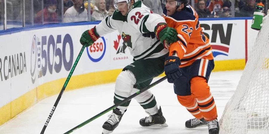 Kevin Fiala (l) von Minnesota Wild und Tyson Barrie von den Edmonton Oilers kämpfen in der ersten Halbzeit um den Puck. Foto: Jason Franson/The Canadian Press via AP/dpa