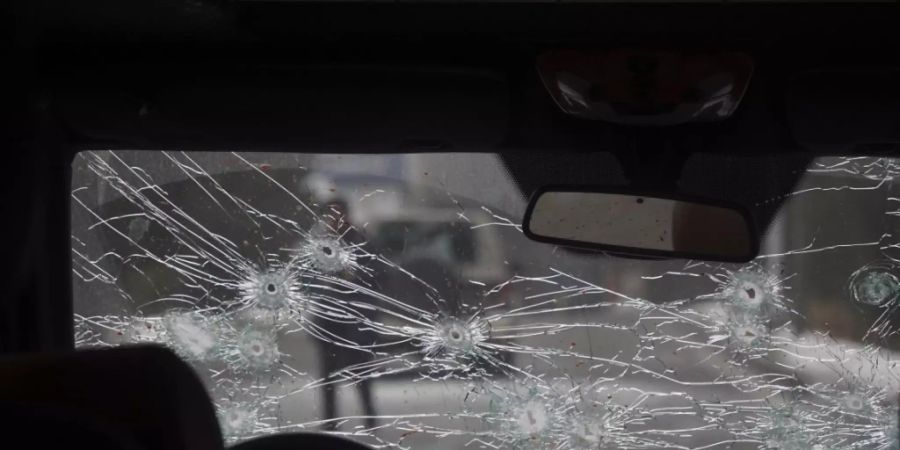 Das Glas der Windschutzscheibe eines Polizeiautos auf einer Strasse in Almaty ist zerbrochen und mit Einschusslöchern versehen. Foto: Vladimir Tretyakov/NUR.KZ/AP/dpa