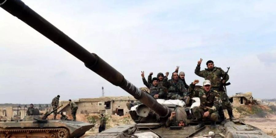 Syrische Soldaten zeigen das «Victory»-Zeichen. Die syrische Armee hat eine wichtige Stadt in der Rebellenhochburg Idlib eingenommen. Foto: SANA/dpa