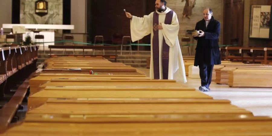In Seriate, einer Gemeinde in der italienischen Provinz Bergamo, werden Särge gesegnet. Italien verzeichnet noch immer die meisten Todesfälle im Zusammenhang mit dem Coronavirus. Foto: Antonio Calanni/AP/dpa