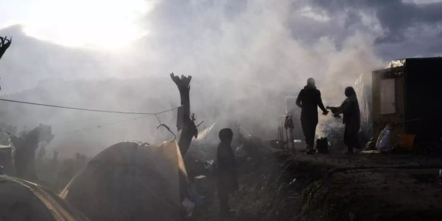 Migranten stehen vor provisorisch errichteten Zelten ausserhalb des Lagers Moria. Der Bau neuer weiterer Lager stösst auf heftige Proteste. Foto: Aggelos Barai/AP/dpa