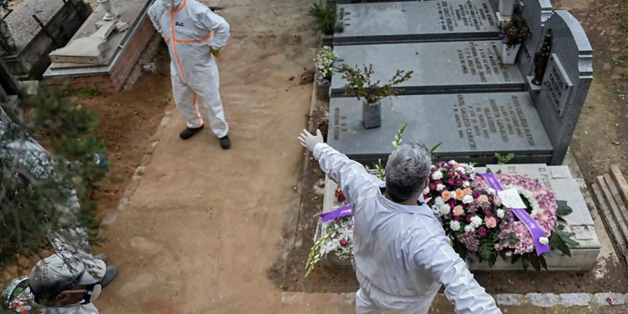 Desinfizieren auf dem Friedhof: Ein städtischer Angestellter desinfiziert einen Kollegen nach einer Beerdigung in Guadalajara.