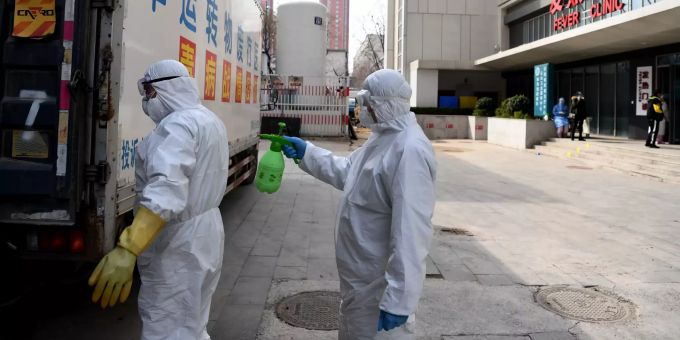 China, Zhengzhou: Ein medizinischer Mitarbeiter wird von einem Kollegen an einem Müllfahrzeug vor dem Henan Provincial People's Krankenhaus desinfiziert. Coronavirus lockdown blind date
