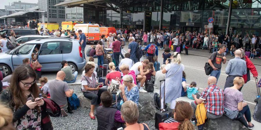 Passagiere warten vor dem Flughafen Hamburg.