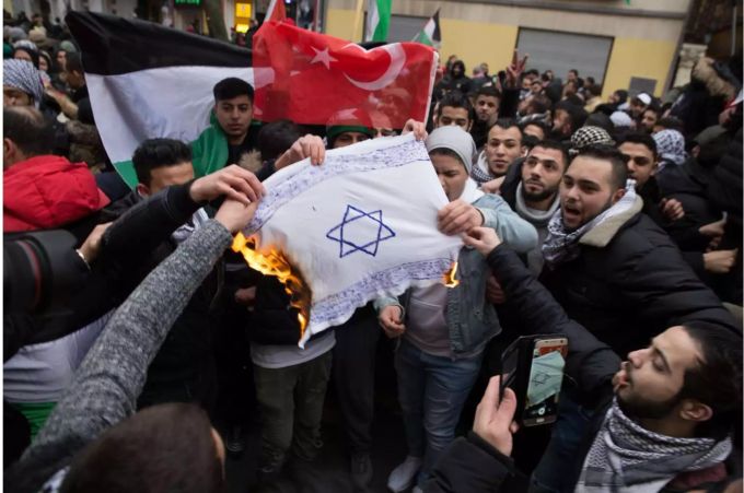 Teilnehmer einer Demonstration verbrennen eine selbstgemalte Fahne mit einem Davidstern im Stadtteil Neukölln. Antisemitismus