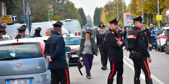 Einsatzkräfte der italienischen Polizei stehen vor einer Postfiliale, in der ein Mafioso Geisel genommen hat.