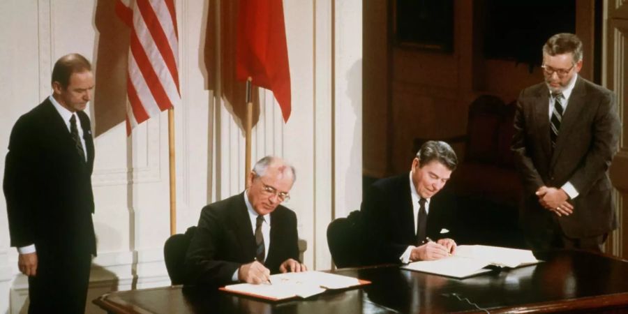 Der damalige US-Präsident Ronald Reagan (r) und der damalige sowjetische Parteichef Michail Gorbatschow unterzeichnen den INF-Vertrag zur Vernichtung der atomaren Mittelstreckenraketen.