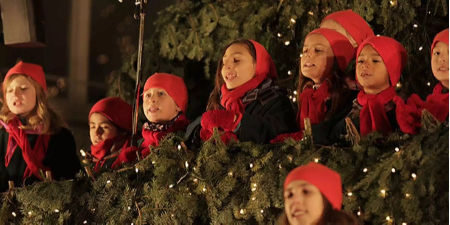 Kinder singen im Singing Christmas Tree auf dem Werdmühleplatz.