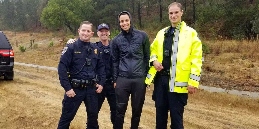 Stephen Curry posiert mit Polizisten für ein Foto.