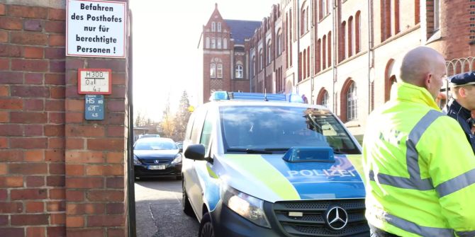 Polizisten sperren die Zufahrt zu einem Postgebäude im Zentrum von Frankfurt an der Oder ab.