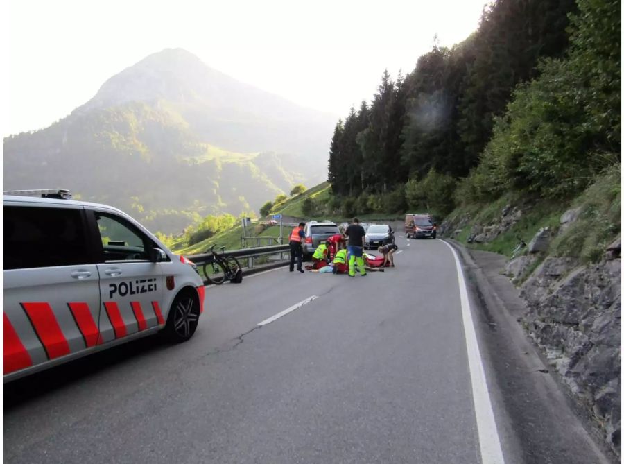 Verunfalltes silbernes und schwarzes Auto am Strassenrand mit Rettungskräften auf der Strasse - zvg Kantonspolizei Glarus