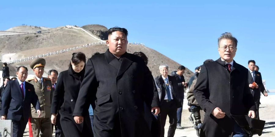 Moon Jae In, Präsident von Südkorea (r), und Kim Jong Un, Machthaber aus Nordkorea, und dessen Ehefrau Ri Sol Ju (dahinter) besichtigen den Gipfel des Vulkans Paektu.