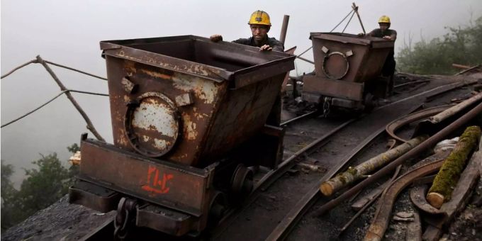 Iranische Kohlminenarbeiter schieben Metallwagons. Iranische Kohlminenarbeiter schieben Metallwagons.