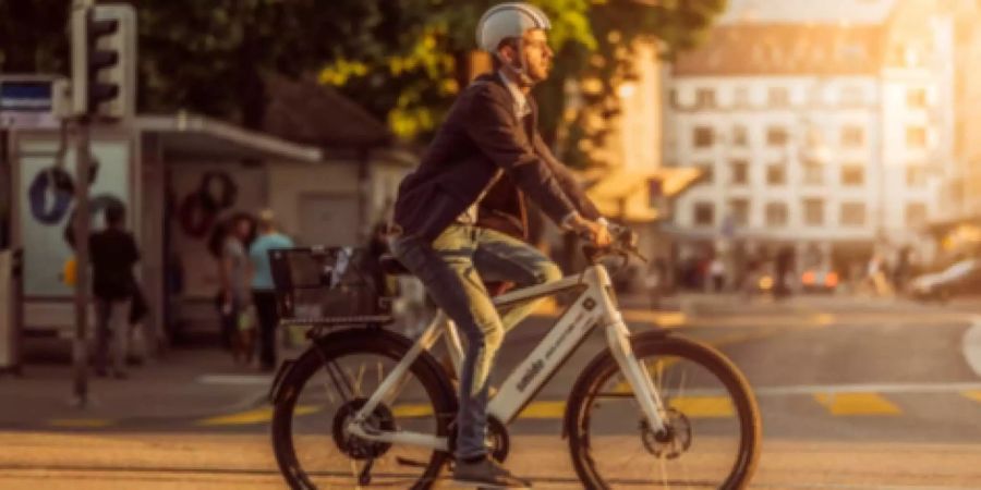 Ein Mann mit Helm fährt mit einem E-Bike von smide durch Zürich.