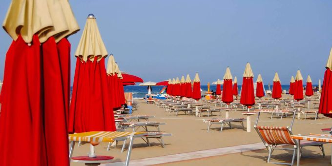 Dutzende Liegestühle und Sonnenschirme am Strand von Rimini (IT). (Symbolbild) Dutzende Liegestühle und Sonnenschirme am Strand von Rimini (IT). (Symbolbild)