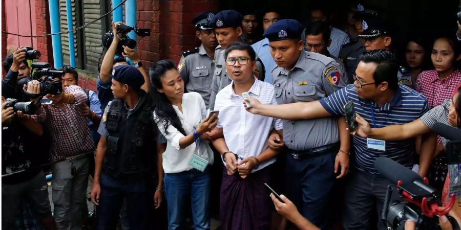 Der Reutersreporter Wa Lone (m.), 31, spricht in Handschellen zu den Medien, als er ein Gericht in der früheren Myanmarer Hauptstadt Rangun verlässt.