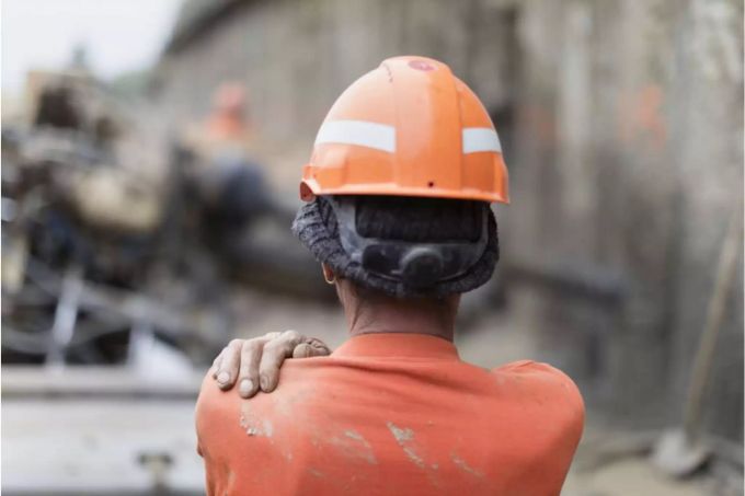 Bauarbeiter von hinten mit Hand auf Schulter - Keystone Bauarbeiter von hinten mit Hand auf Schulter - Keystone