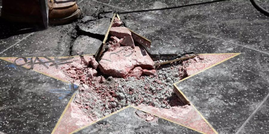 Arbeiter entfernen die zerstörten Teile beim Stern von US-Präsident Donald Trump auf dem Walk of Fame in Hollywood (Kalifornien, USA).