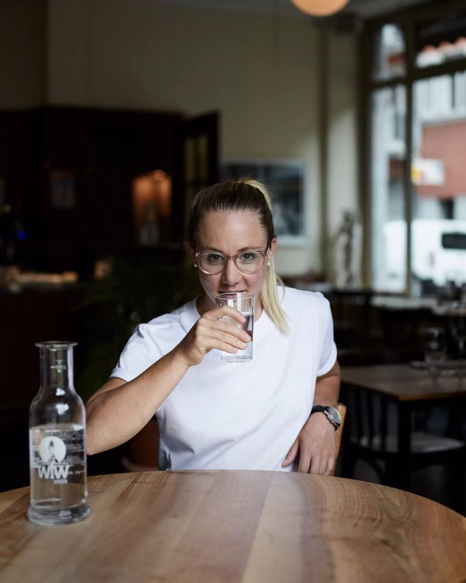 Ariella Kaeslin setzt beim Besuch ihres Lieblings WfW-Partnerrestaurants auf Leitungswasser. Frau im Restaurant