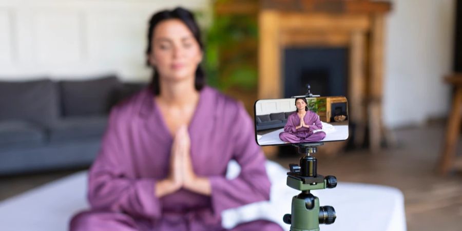 Frau Yoga Video drehen Smartphone Stativ