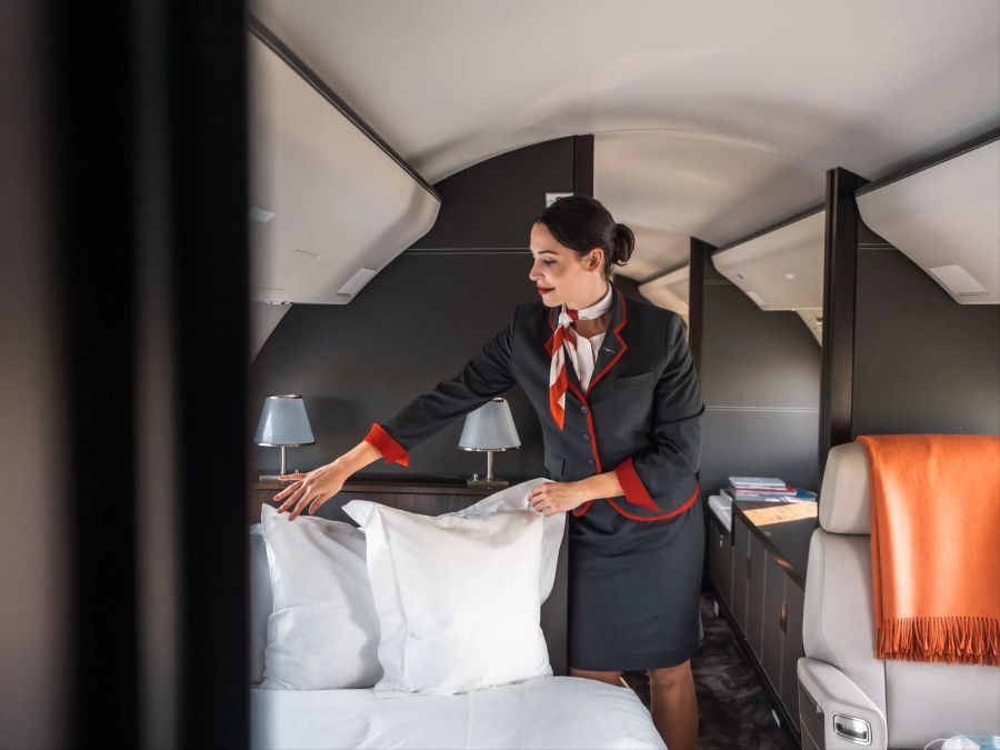 Stewardess macht eine Bett im Privatflugzeug.