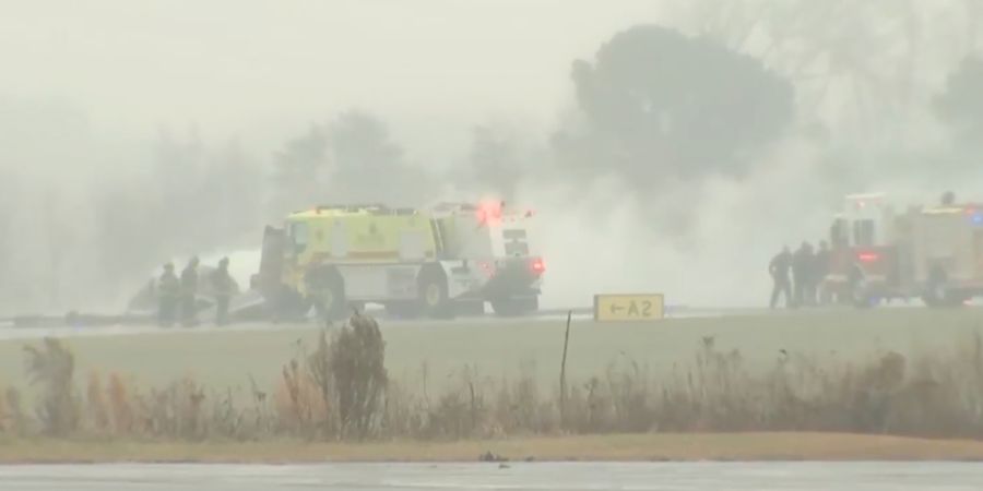HANDOUT - Feuerwehrleute sind bei einem Flugzeugabsturz auf einem Regionalflughafen in North Carolina im Einsatz. Foto: Uncredited/WSOC via AP/dpa - ACHTUNG: Nur zur redaktionellen Verw...